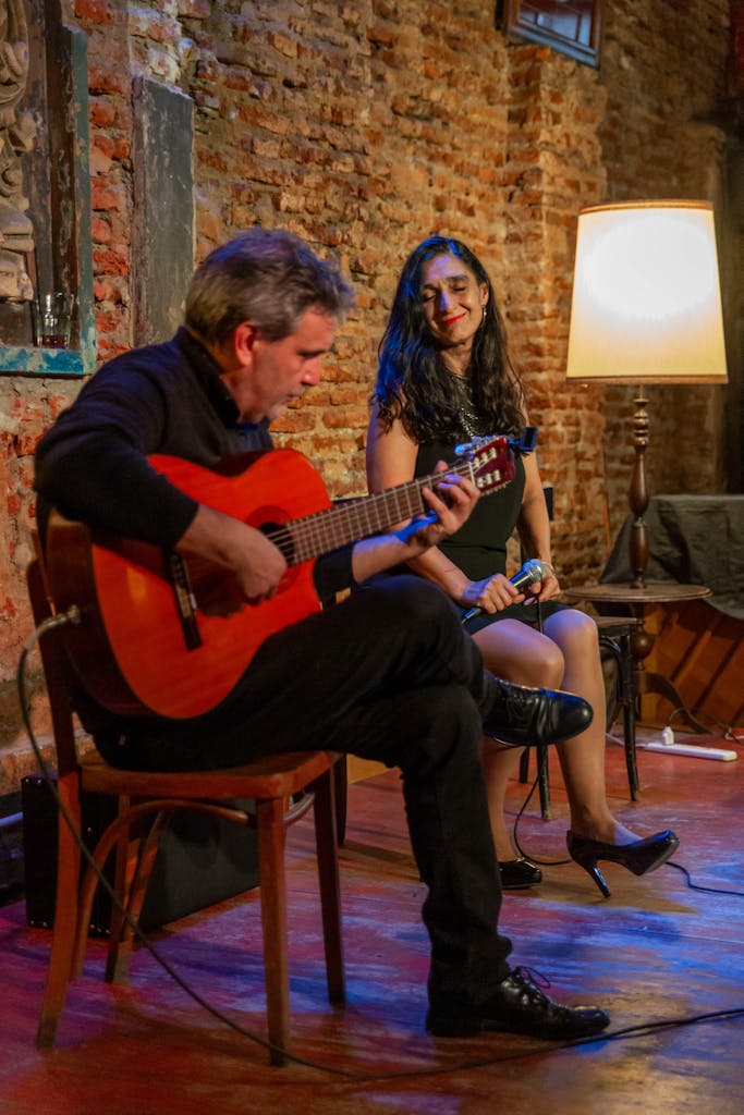 A guitarist performs live in a cozy, rustic setting with warm lighting in Mar del Plata.