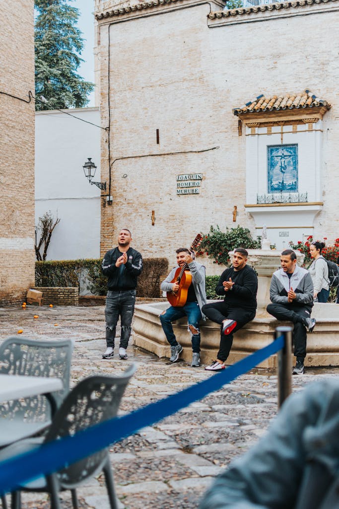 Four street musicians performing traditional music in a Sevilla plaza.